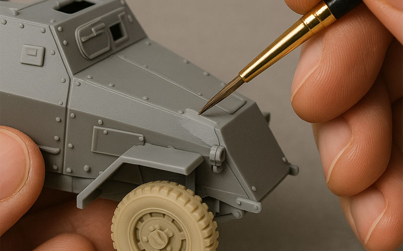 Applying thin coats of acrylic paint with a fine brush on a model kit